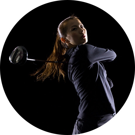 woman swinging golf club