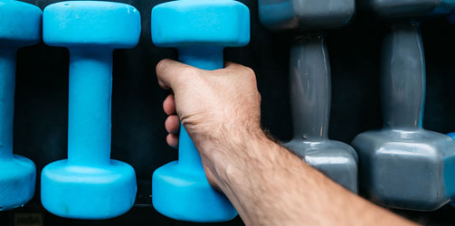 Hand reaching for weight Hand reaching for weight